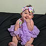 Angélique joined the competition — help win amazing prizes! baby, black_couch, child, clothing, couch, cute, fabric, hand, happy, headband, human, indoors, infant, person, playful, portrait, purple_dress, sitting, smiling, toddler