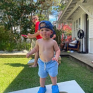 Sawyer joined the competition — help win amazing prizes! child, toddler, boy, outdoor, backyard, portrait, smiling, baseball_cap, blue_clogs, shirtless, shorts, cornhole, beanbags, lawn, house, porch, trees, sunlight, family, summer