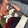 person, cat, glasses, kiss, laptop, blanket, couch, indoor, relaxation, affection, gray_cat, white_cat, casual_clothing, female, technology, comfort, home, feline, closeup, intimacy