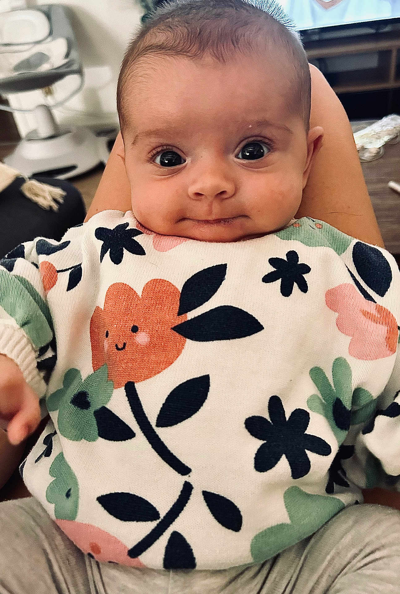 Louna participe au concours pour gagner de l'argent avec cette photo : baby, infant, child, face, eyes, sweater, floral_pattern, clothing, person, cute, indoors, seated, expression, smile, skin, head, hands, legs, cozy, warm