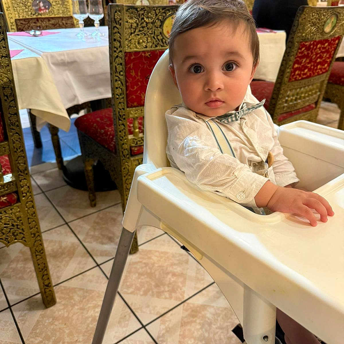 Viaansh participe au concours pour gagner de l'argent avec cette photo : baby, bow_tie, chair, child, clothing, decor, dining, eyes, face, floor, furniture, hand, high_chair, interior, person, restaurant, sitting, table, tile_floor, waiter