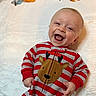 Björn joined the competition — help win amazing prizes! baby, child, smiling, laughing, onesie, red_stripes, reindeer, festive_clothing, blanket, soft_texture, happy, cute, infant, portrait, indoor, holiday, cheerful, face, head, hands