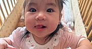 Kaia joined the competition — help win amazing prizes! baby, child, close_up, crib, cute, face, hand, indoor, infant, mattress, nursery, person, pigtails, pillow, pink_clothing, playful_expression, smiling, tongue_out, wooden_crib, young_child