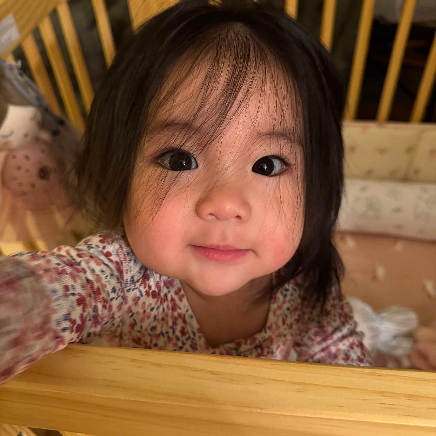 Kaia joined the competition — help win amazing prizes! toddler, child, baby, face, eyes, hair, crib, wooden_crib, blanket, plush_toy, hand, clothing, indoor, portrait, cute, expression, person, closeup, smile, nursery