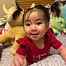 baby, child, smile, pigtails, red_shirt, plush_toy, stuffed_animal, bedroom, blanket, indoor, happy, cute, infant, person, portrait, toy, childhood, face, young, home