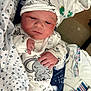 Aiden James joined the competition — help win amazing prizes! newborn, baby, infant, pajamas, hat, blanket, clothing, face, hand, sleepwear, cute, soft, indoors, resting, cozy, patterned, animal_print, child, person, portrait