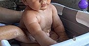 Gael Alexander joined the competition — help win amazing prizes! adult_arm, baby, bath, bath_seat, bathroom, bathtub, child, closeup, dark_hair, home, indoor, infant, portrait, purple_toy, safe_bathing, serious_expression, sitting, support, water, wet