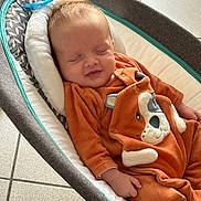 Timothé participe au concours pour gagner de l'argent avec cette photo : baby, baby_rocker, child, comfort, cushion, cute, face, floor_tiles, hand, indoor, infant, napping, onesie, orange_clothing, pacifier, peaceful, portrait, resting, sleeping, small