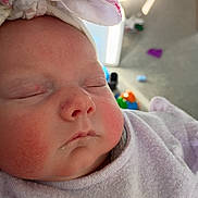 Peyton is registered to the contest to win money with this photo: baby, infant, sleeping, face, rosy_cheeks, headband, clothing, soft_fabric, closeup, portrait, indoor, child, cute, peaceful, newborn, person, sleep, adorable, pink, soft_lighting