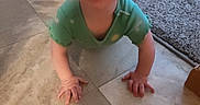 Riki is registered to the contest to win money with this photo: baby, carpet, child, couch, crawling, cute, expression, eyes, floor, green_onesie, hands, happy, head, home, indoor, infant, person, smile, tile_floor, young