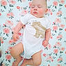 baby, infant, sleeping, onesie, bear_print, floral_pattern, blanket, cute, peaceful, child, skin, foot, hand, head, face, lying_down, indoors, soft_colors, portrait, adorable