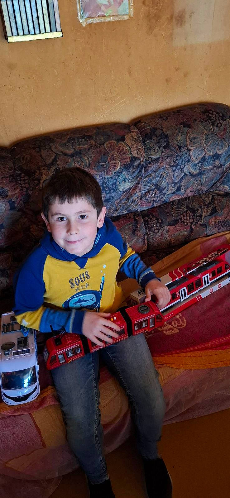 Matheo a rejoint le concours — aidez-le/la à gagner de superbes lots ! architecture, boy, building, child, clothing, couch, cushion, face, furniture, head, homedecor, indoors, jeans, livingroom, male, pants, person, photography, portrait, t_shirt