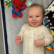 Parker joined the competition — help win amazing prizes! baby, infant, smiling, sticking_tongue, onesie, toys, playpen, spiderman_plush, plush_toy, teether, colorful, play_mat, star_pattern, rosy_cheeks, crib_mesh, lying_down, close_up, portrait, happy, chubby_cheeks