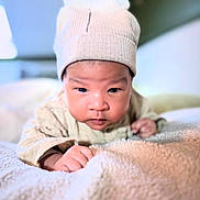 Thaïm participe au concours pour gagner de l'argent avec cette photo : baby, infant, hat, blanket, closeup, face, cute, child, indoors, portrait, soft, warm, cozy, young, skin, expression, person, clothing, sleepwear, rest