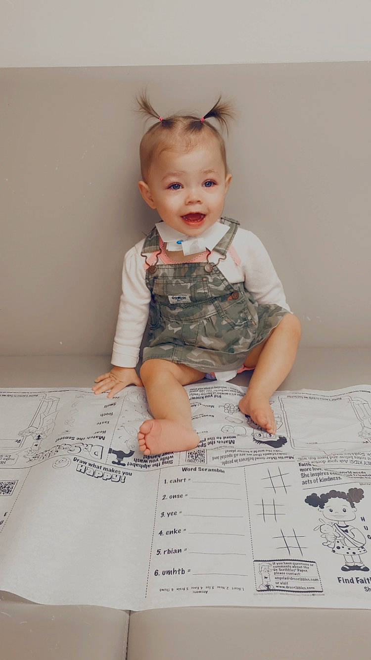 Lynlee is registered to the contest to win money with this photo: baby, baby_toddler_clothing, child, dress, fashion_design, flooring, font, fun, happy, illustration, paper, paper_product, pattern, person, sitting, sleeve, smile, stationery, t_shirt, toddler
