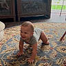baby, crawling, rug, indoor, carpet, furniture, wood_floor, baby_clothing, smiling, child, home, living_room, natural_light, pet_bed, wooden_chair, cute, happy, floor, infant, small_child