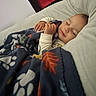 baby, blanket, sleeping, couch, cozy, child, indoor, peaceful, smile, rest, comfort, soft, pajamas, nap, young_child, portrait, hand, head, face, relaxation