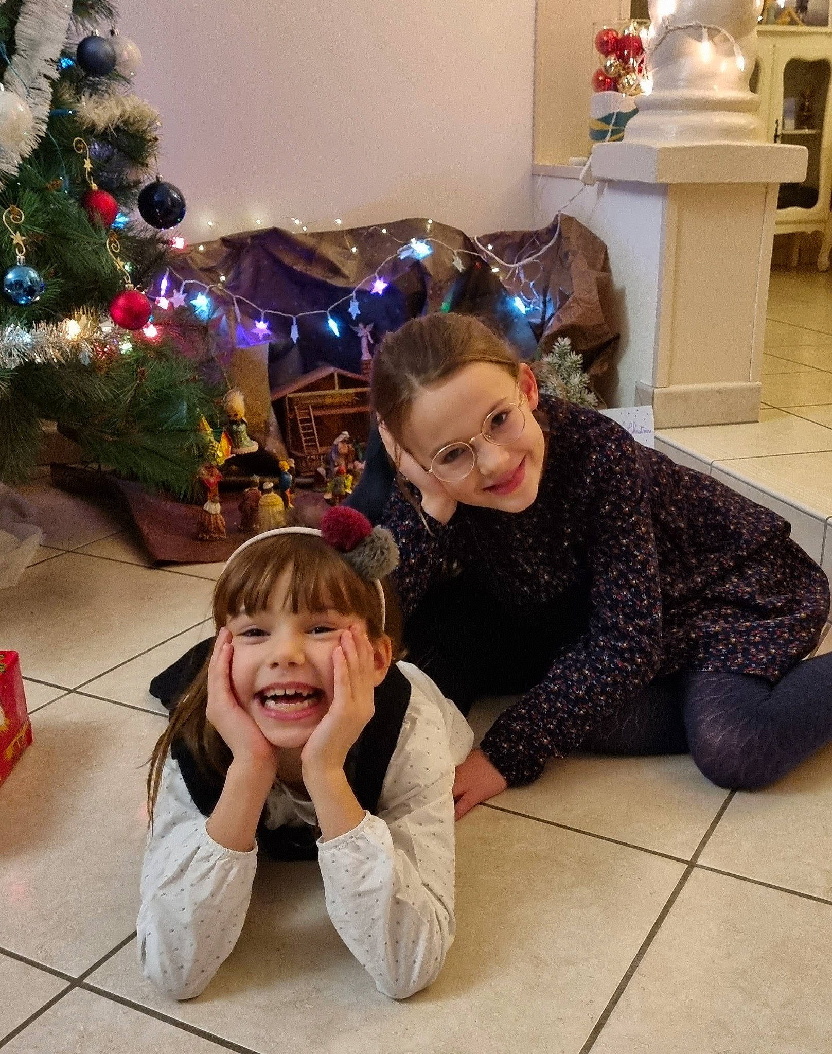 Flore participe au concours pour gagner de l'argent avec cette photo : beauty, child, christmas_ornament, christmas_tree, event, floor, flooring, fun, happy, holiday, holiday_ornament, joy, lap, people, person, photograph, smile, snapshot, standing, toddler