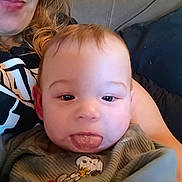 Oliver joined the competition — help win amazing prizes! baby, tongue, face, child, person, adult, clothing, indoor, sofa, couch, hair, sitting, smiling, cute, playful, expression, closeup, portrait, snoopy, green