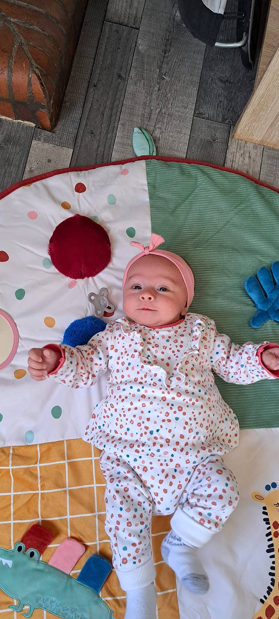 Noéline a rejoint le concours — aidez-le/la à gagner de superbes lots ! baby, baby_products, baby_toddler_clothing, baby_toys, beanie, child, comfort, headwear, knit_cap, linens, pattern, peach, person, pink, plaid, polka_dot, room, sitting, sleeve, textile