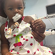 Preesha joined the competition — help win amazing prizes! adult, baby, cabinet, cherry_pattern, child, clothing, curly_hair, cute, dress, face, hand, holding, indoor, medical_equipment, pacifier, person, portrait, shelf, skin, toddler