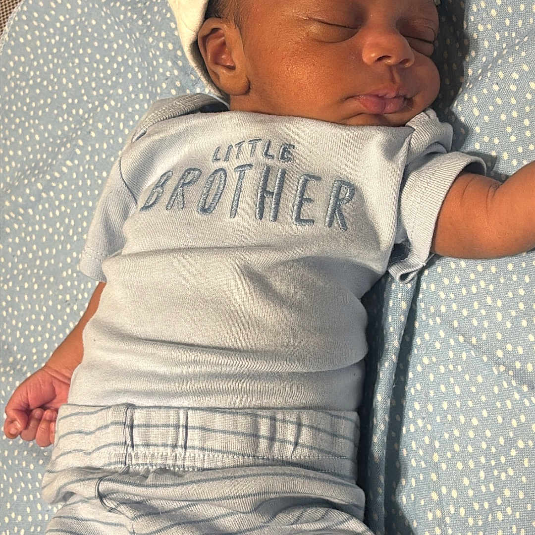 Josiah Lewis joined the competition — help win amazing prizes! baby, sleeping, infant, hat, clothing, striped_pants, blanket, blue, cute, peaceful, face, newborn, child, person, soft, resting, little_brother, toddler, indoors, cozy