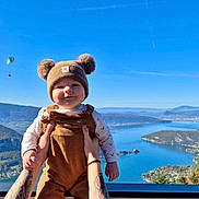 Valentin a rejoint le concours — aidez-le/la à gagner de superbes lots ! baby, child, person, hat, clothing, outdoor, sky, mountain, lake, water, nature, paraglider, hands, smile, scenery, blue_sky, forest, fall, sunny, portrait