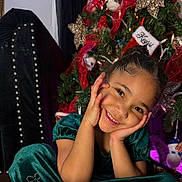 Luna joined the competition — help win amazing prizes! child, girl, smiling, green_dress, christmas_tree, holiday, festive, decorations, ribbons, ornaments, happy, portrait, indoors, celebration, cute, joyful, face, hands, seated, christmas