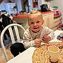 Eva a rejoint le concours — aidez-le/la à gagner de superbes lots ! child, toddler, smiling, indoor, kitchen, table, chair, breadstick, cup, placemat, blond_hair, casual_clothing, happy, portrait, person, home, furniture, food, cute, young