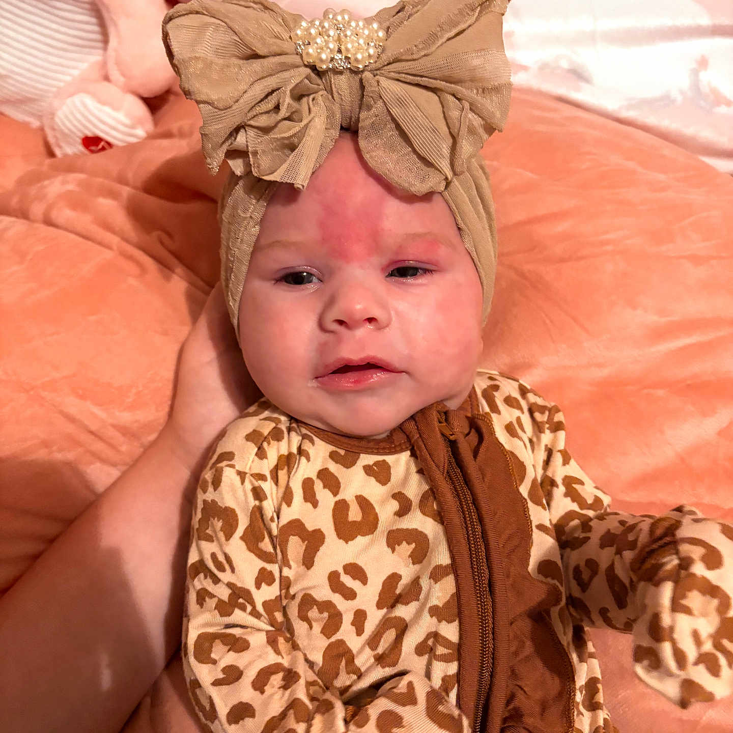 Maxlynn joined the competition — help win amazing prizes! animal_print, baby, blanket, bow, child, cute, expression, face, hand, headband, indoors, infant, leopard_print, onesie, person, plush_toy, resting, skin, sleepwear, soft_texture
