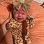Maxlynn is registered to the contest to win money with this photo: baby, crying, headband, leopard_print, onesie, infant, hand, blanket, pearl, ruffle, soft_texture, facial_expression, newborn, clothing, person, sleepwear, cute, indoor, pink, child