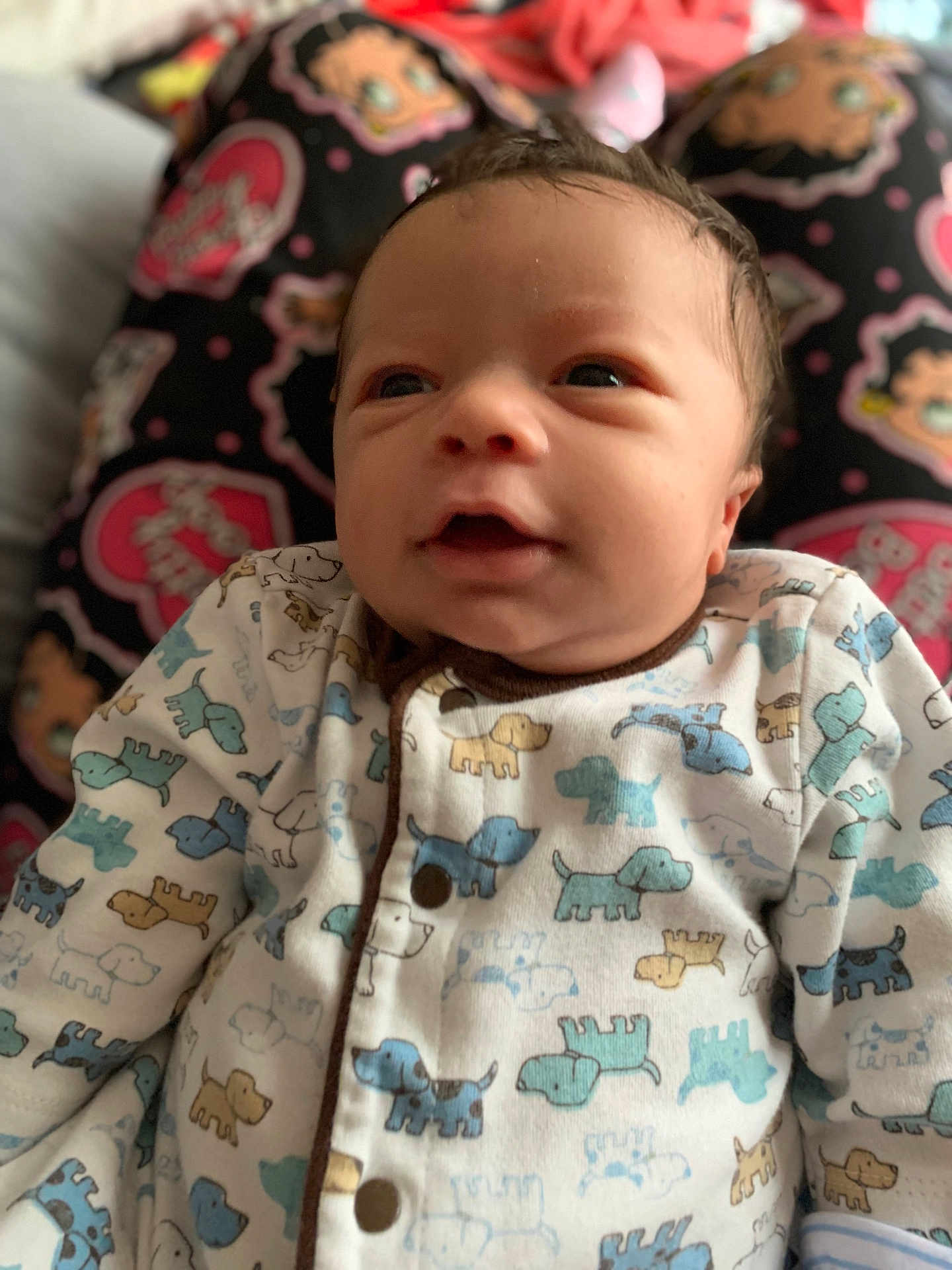 Koa is registered to the contest to win money with this photo: adorable, baby, bedding, blanket, close_up, cute, dog_pattern, eyes, face, hair, indoors, infant, mouth, newborn, newborn_sleepwear, onesie, pillow, portrait, smile, soft_lighting
