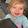 Leah is registered to the contest to win money with this photo: toddler, child, baby, portrait, smiling, tongue_out, blue_eyes, blonde_hair, indoor, living_room, couch, pillow, carpet, shirt, clothing, face, close_up, sitting, happy, home