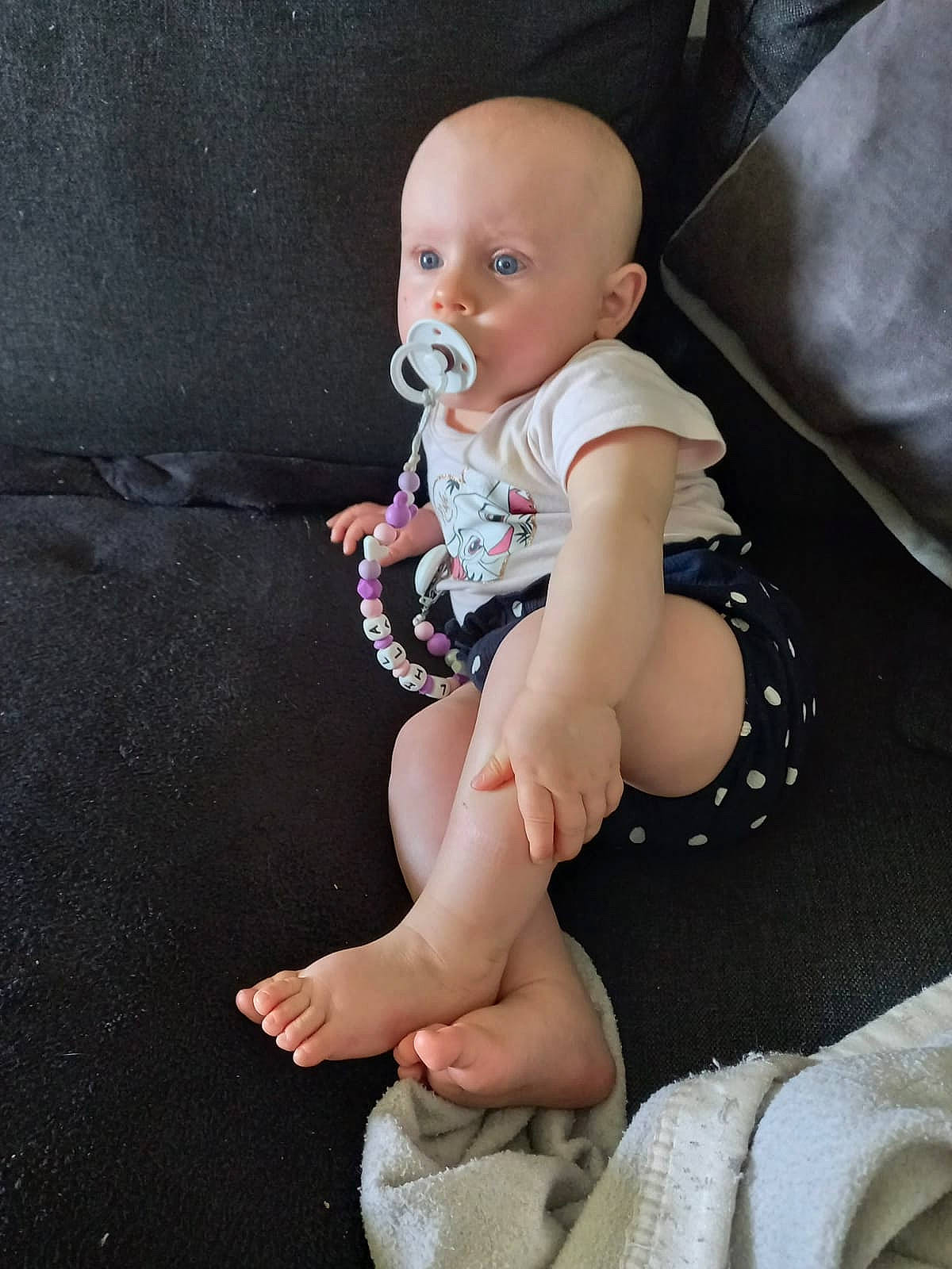 Lila a rejoint le concours — aidez-le/la à gagner de superbes lots ! baby, baby_toddler_clothing, barefoot, comfort, elbow, eye, flash_photography, foot, head, human_body, human_leg, iris, knee, person, skin, sleeve, sock, stomach, thigh, thumb