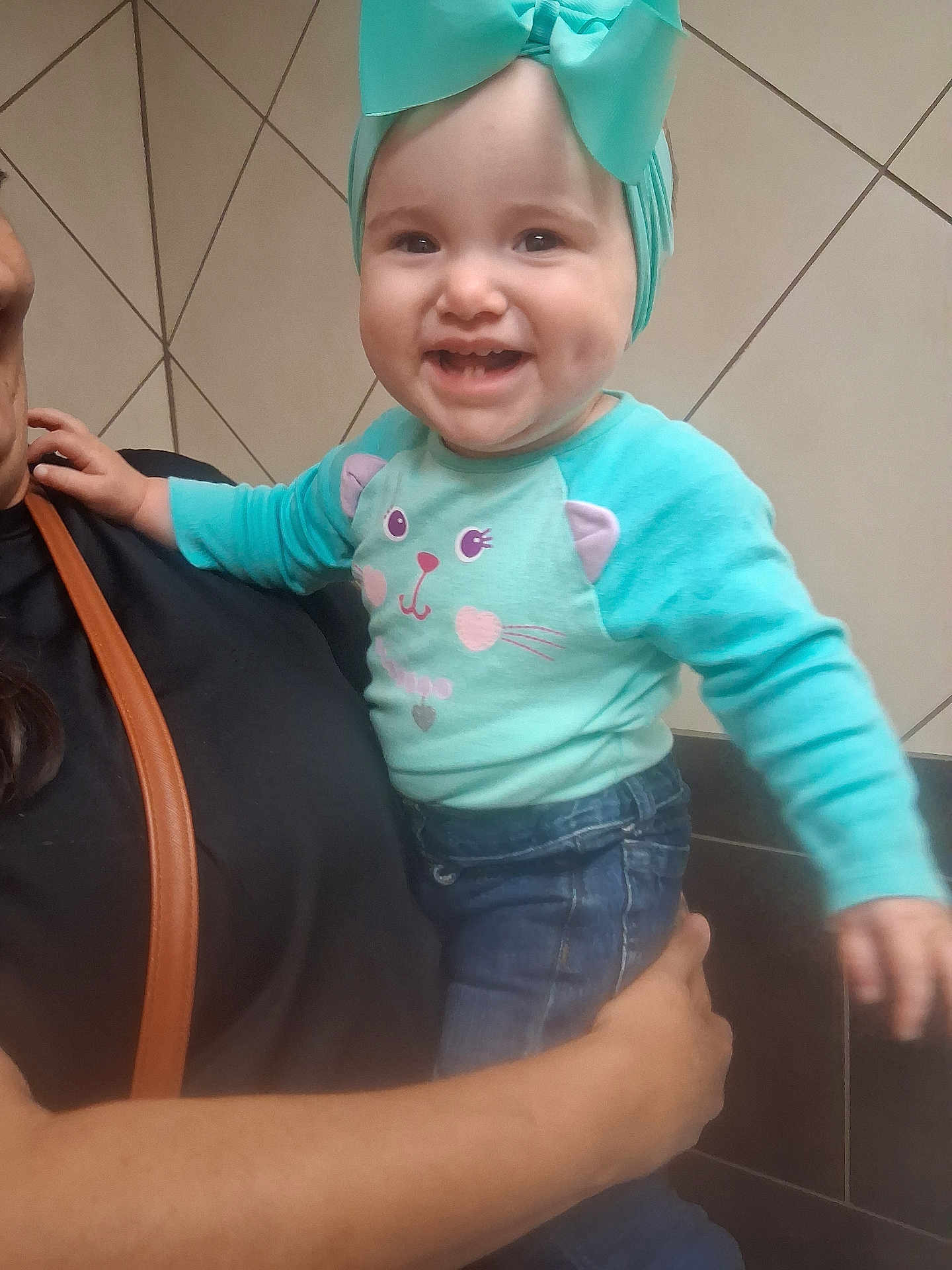 Willow joined the competition — help win amazing prizes! toddler, child, smiling, person, adult, holding, headband, bow, turquoise, sweater, cat_face, jeans, hand, arm, indoor, tile_wall, happy, cute, clothing, portrait