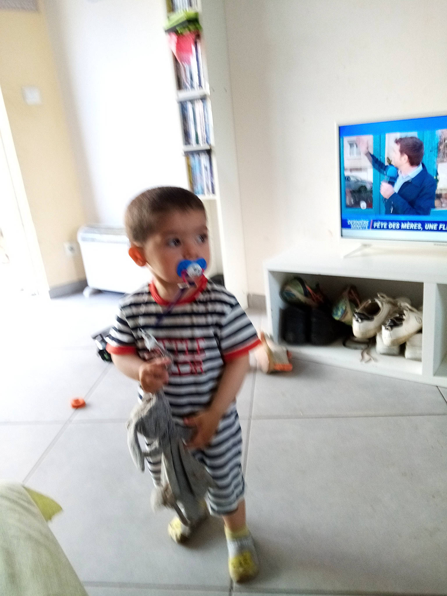 Alessandro a rejoint le concours — aidez-le/la à gagner de superbes lots ! baby_toddler_clothing, child, door, floor, flooring, hardwood, home, home_appliance, knee, led_backlit_lcd_display, leg, person, shelf, shelving, shorts, sleeve, t_shirt, television, television_set, toddler