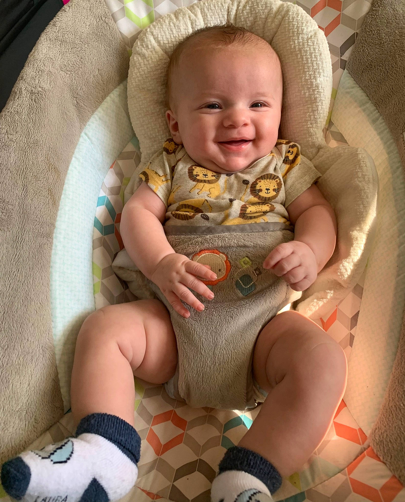 Paxton is registered to the contest to win money with this photo: baby, baby_carriage, baby_products, baby_toddler_clothing, chair, cheek, comfort, eye, face, happy, human_body, human_leg, joy, knee, lap, leg, person, pink, skin, smile
