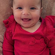 Aria joined the competition — help win amazing prizes! baby, smiling, red_clothing, infant, face, happy, cushion, blanket, indoor, child, portrait, cute, seated, young_child, apparel, warm, cozy, babysitter, joy, expression