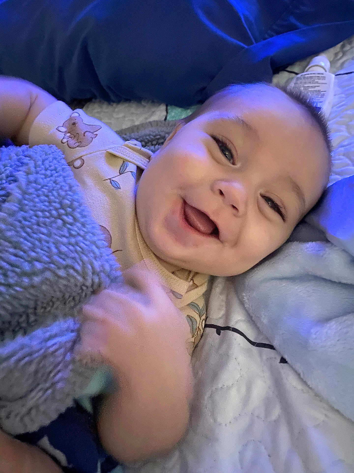 Carson joined the competition — help win amazing prizes! baby, smiling, blanket, bed, infant, face, hand, happy, cozy, sleepwear, pillow, cute, child, soft, relaxed, indoors, comfort, portrait, young, expression