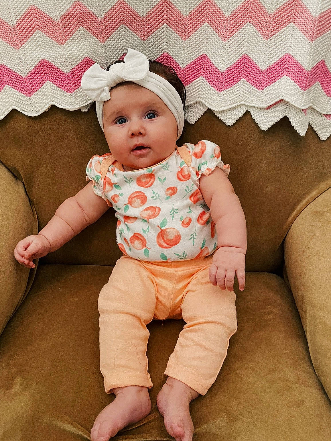 Everley is registered to the contest to win money with this photo: baby, baby_toddler_clothing, cheek, child, collar, comfort, face, finger, foot, happy, headwear, human_leg, pattern, peach, person, pink, sitting, skin, sleeve, textile