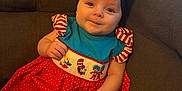 Gracie is registered to the contest to win money with this photo: baby, child, infant, couch, clothing, striped, red, white, blue, black_bow, smiling, sitting, indoors, cute, portrait, person, fabric, pattern, home, cozy