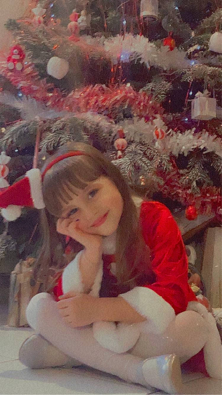 Chloé a rejoint le concours — aidez-le/la à gagner de superbes lots ! christmas_decoration, christmas_ornament, christmas_tree, event, eye, happy, holiday_ornament, human_body, human_leg, joy, lap, long_hair, ornament, person, pink, plant, smile, textile, thigh, tree