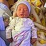 Atlas is registered to the contest to win money with this photo: newborn, baby, sleeping, infant, portrait, hospital, blanket, swaddle, hat, cap, onesie, baby_clothing, face, closed_eyes, peaceful, lying_down, caregiver, tattoo, medical_setting, indoor