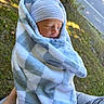 newborn, baby, sleeping, infant, portrait, blanket, swaddled, hat, striped_hat, blue, outdoor, held, peaceful, face, closed_eyes, road, trees, grass, daylight, cozy