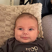 Giulia participe au concours pour gagner de l'argent avec cette photo : baby, infant, face, smile, clothing, pillow, blanket, indoor, couch, person, head, cute, child, eyes, soft_texture, black_handbag, relaxing, cozy, expression, portrait