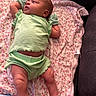baby, infant, green_clothing, blanket, floral_pattern, lying_down, indoors, soft_fabric, cute, child, newborn, relaxed, skin, legs, arms, head, face, expression, comfort, resting