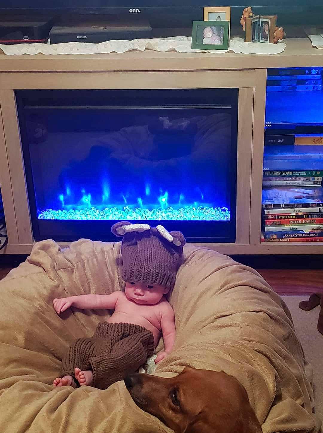 Jaxson is registered to the contest to win money with this photo: blue, comfort, display_device, electric_blue, electronic_device, flat_panel_display, fun, gas, headwear, heat, home_appliance, light, lighting, muscle, person, pillow, room, shelf, sky, television