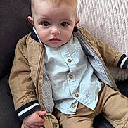 Elio participe au concours pour gagner de l'argent avec cette photo : baby, infant, child, couch, pillow, jacket, shirt, pants, hand, face, eyes, sitting, indoor, wooden_sign, months, clothing, portrait, cute, expression, soft_lighting