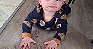Elio participe au concours pour gagner de l'argent avec cette photo : baby, child, crawling, floor, wooden_floor, onesie, animal_print, indoor, home, furniture, carpet, curious, face, hands, head, person, infant, expression, eyes, clothing