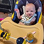 William is registered to the contest to win money with this photo: baby, baby_food, bib, carpet, child, face, furniture, happy, high_chair, home, indoor, infant, person, playpen, seat_belt, smiling, spoon, table, toy, waving